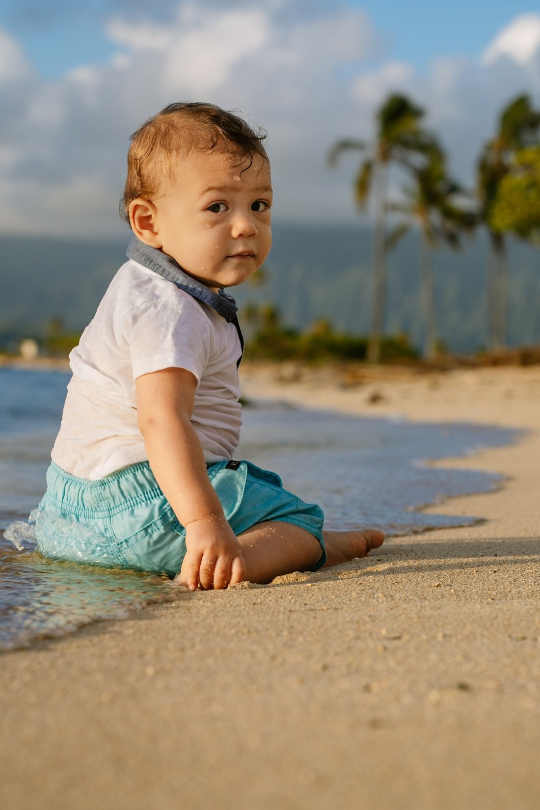 baby after getting splashed by water at the beach in hawaii