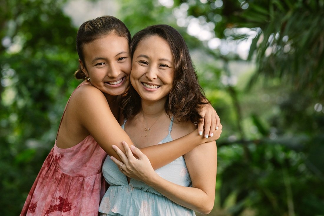 portrait of mom and teenage daughter hugging during oahu family photoshoot