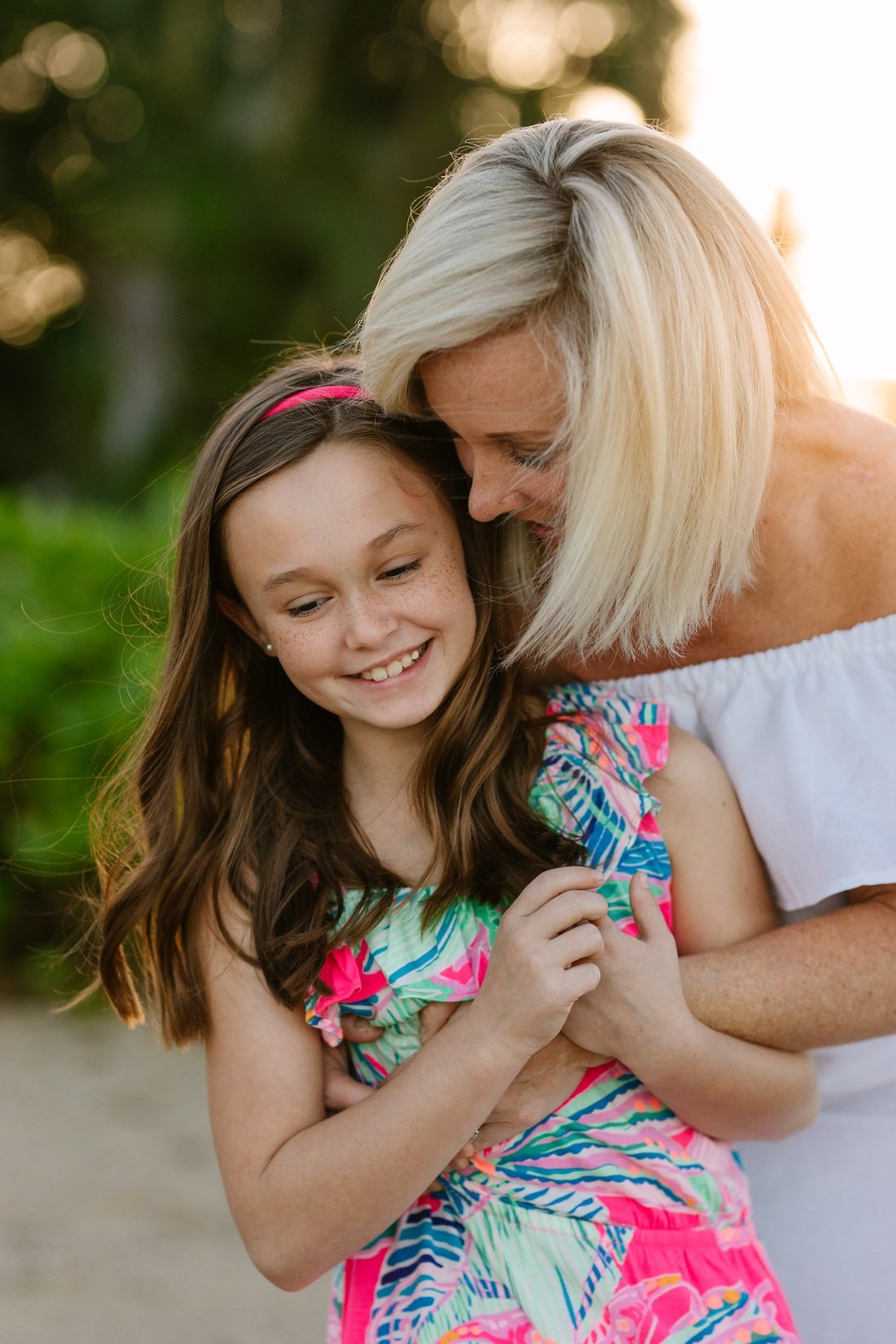 mom and daughter share a laugh during an oahu family photographer session by little bird
