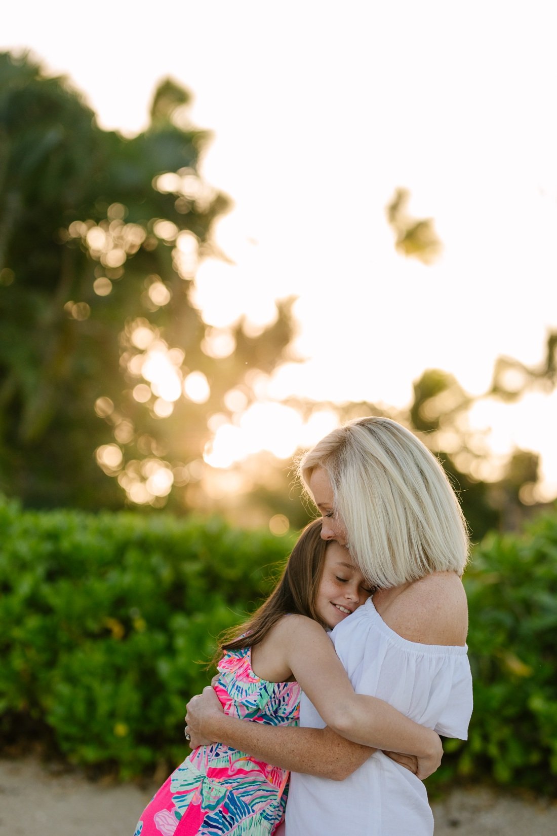 daughter gives mom a big hug at sunrise during a family photo session