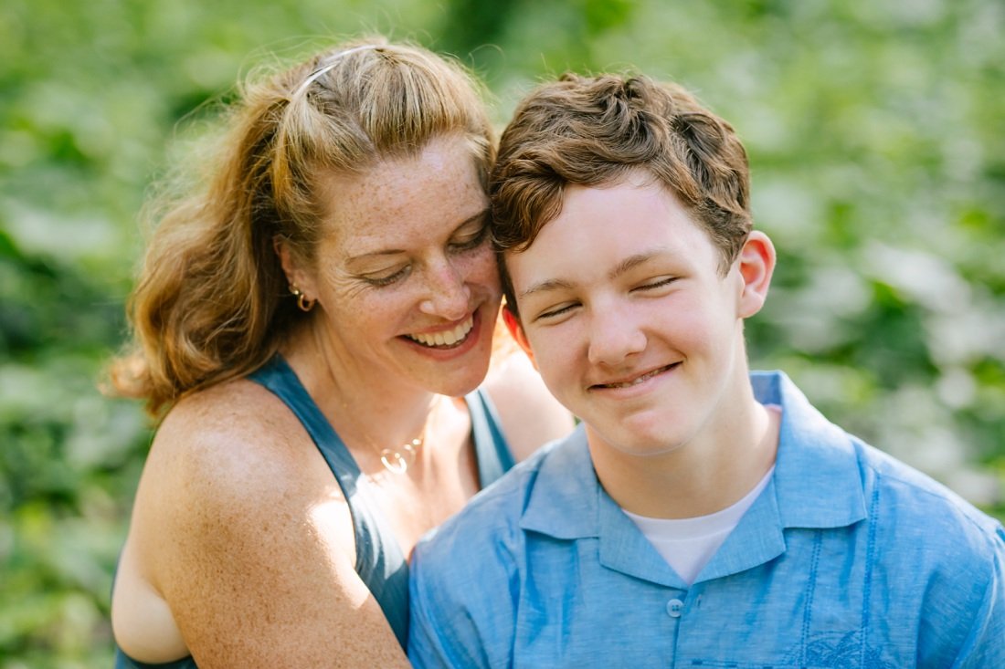 mom and teenage son share a moment during a family photo session in hawaii