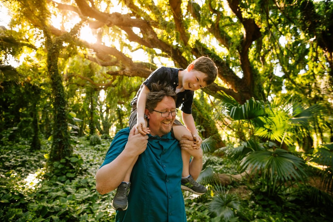 dad carries son on his shoulders in a Maui rainforest during a family photoshoot
