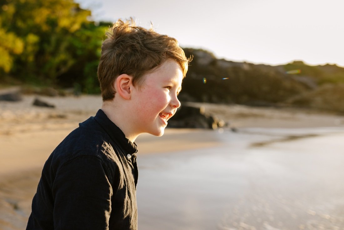 boy smiling in the golden light during family photos at kapalua bay