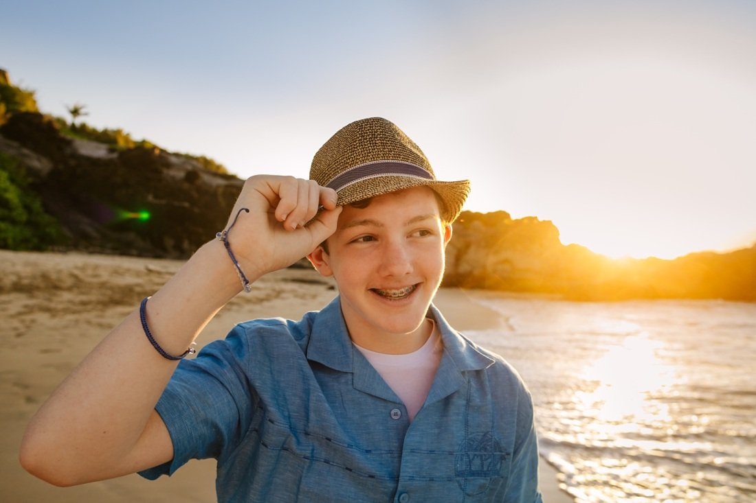 portrait of a teen boy wearing a hat at  sunset in maui for family photos