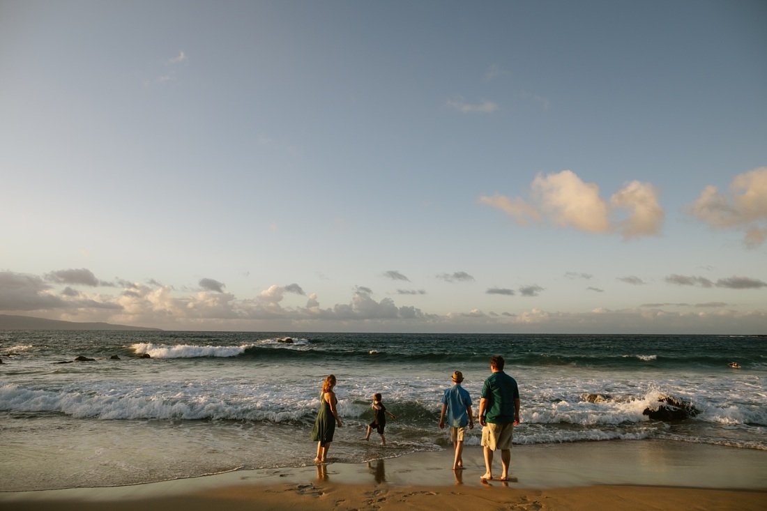 family watches the waves at sunset in maui
