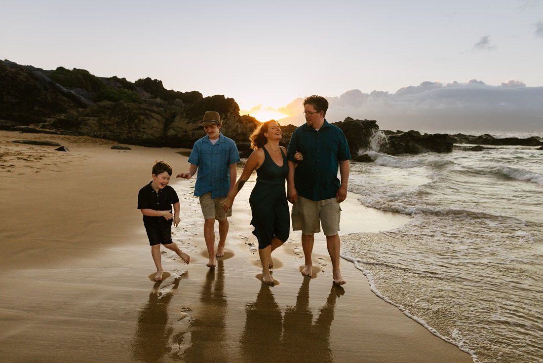 family walks along the beach at sunset at kapalua beach maui