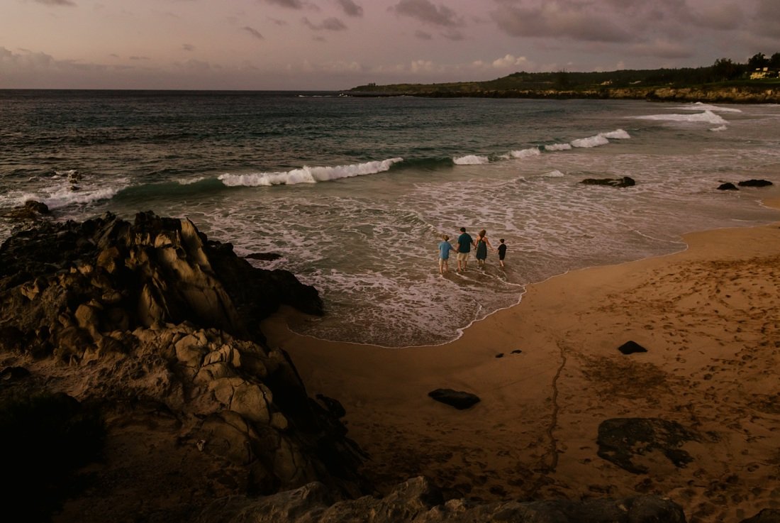 view of a family on the beach from the cliffs at kapalua bay