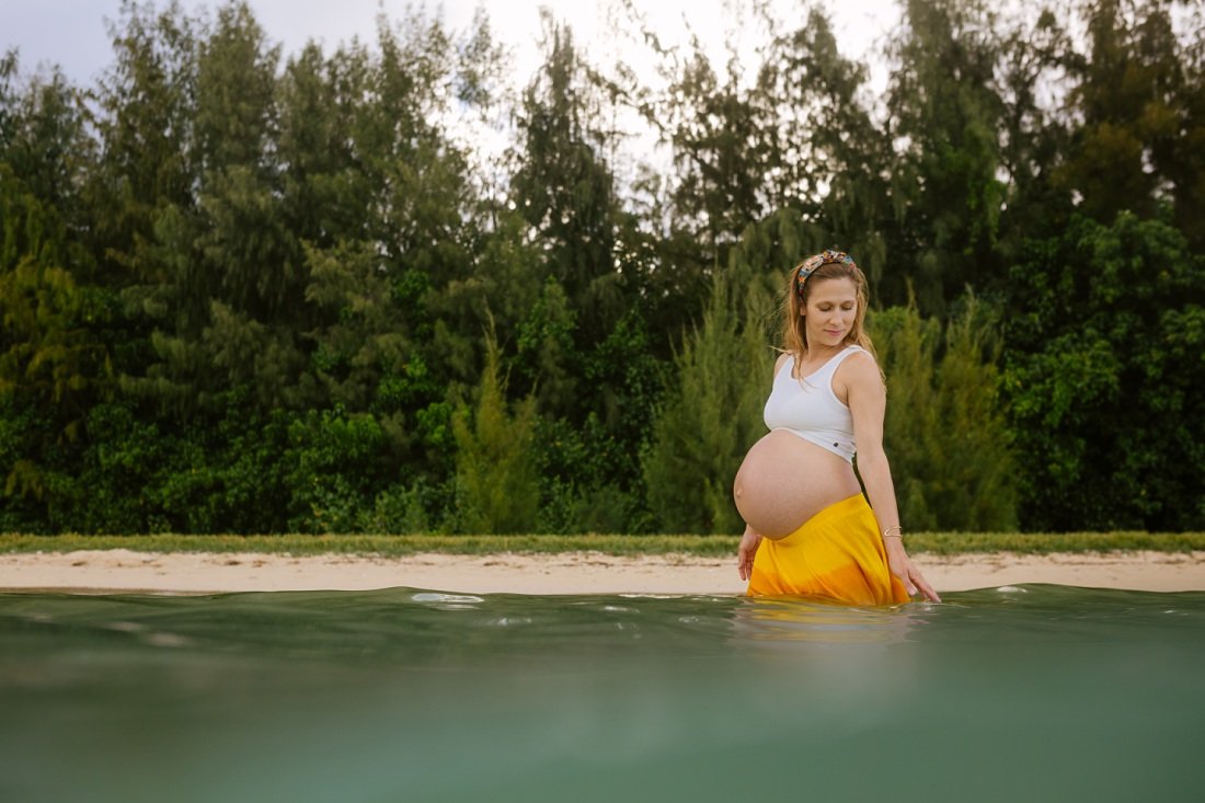 pregnant woman in yellow skirt in the water