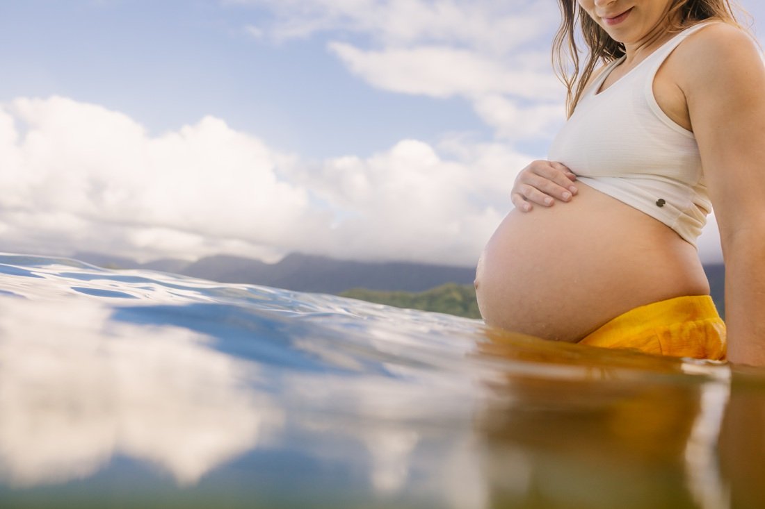 underwater maternity portrait with sky reflection windward oahu