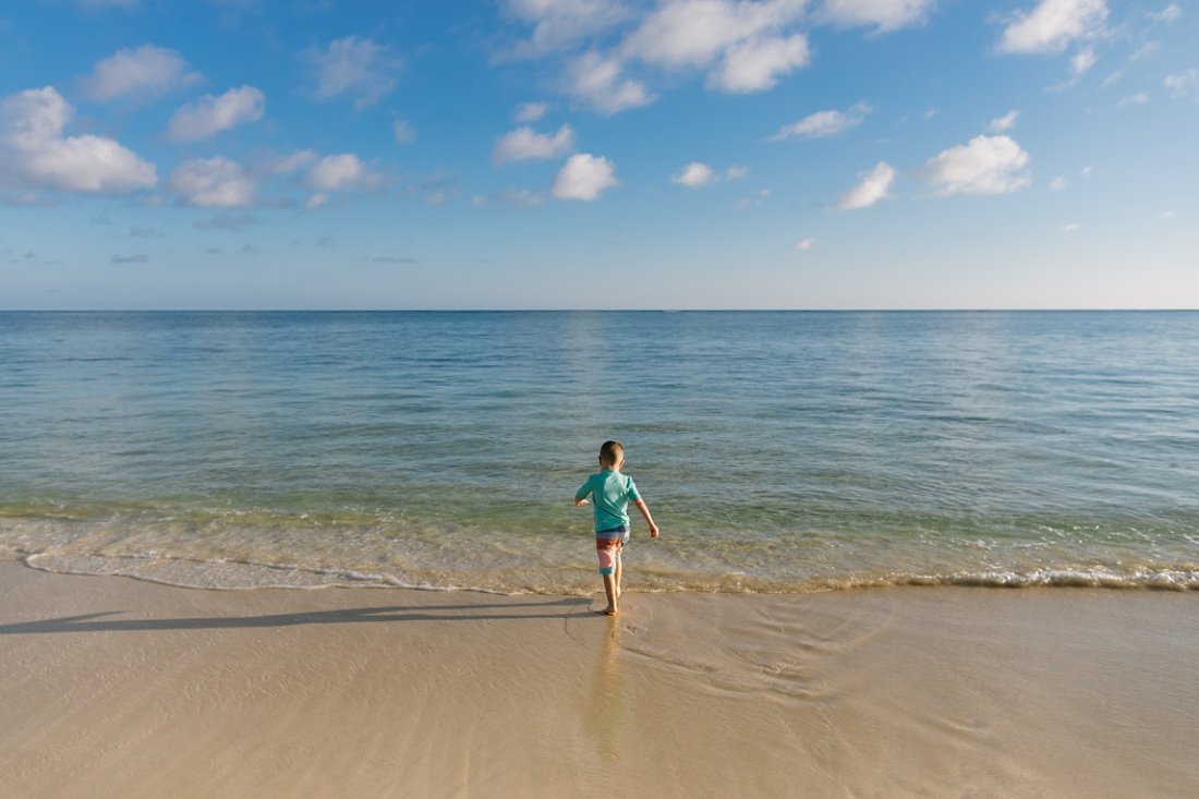 pre-school boy explores the shallows of lanikai beach Family photographers in Oahu
