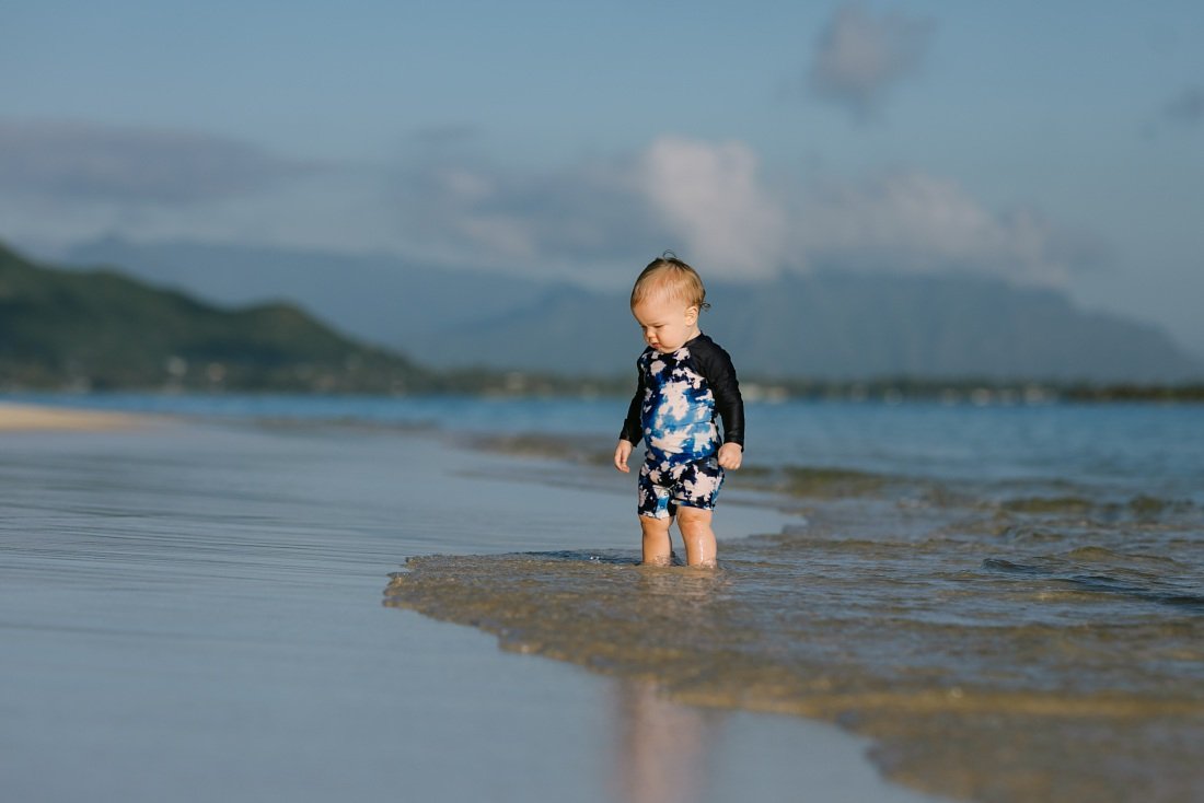 Family photographers in Oahu capture baby playing in the shallows at lanikai