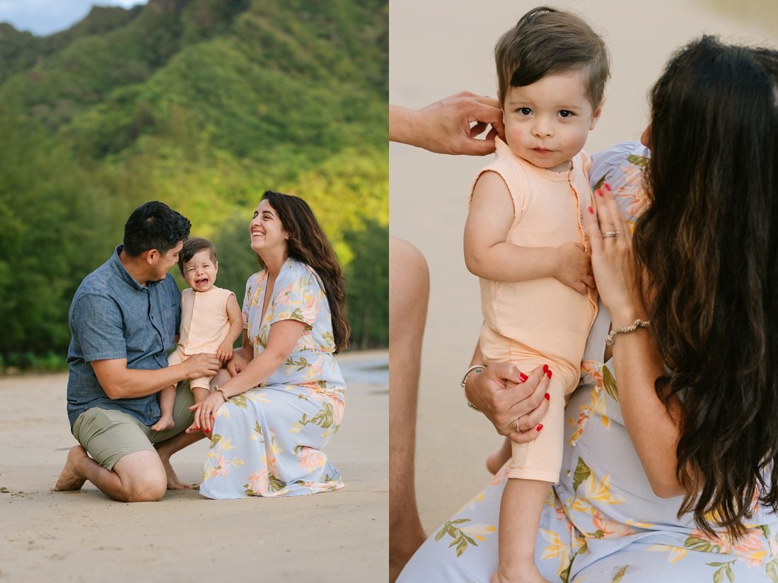 a couple comforts a crying baby at a beach photo session in oahu