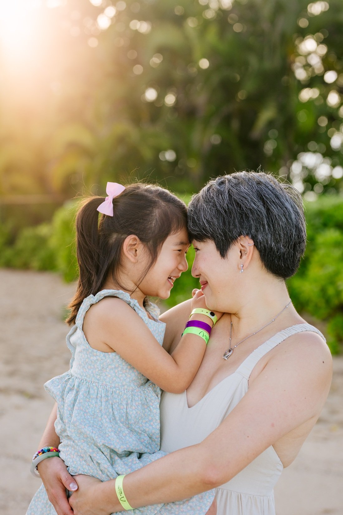 mom and daughter snuggle close at sunrise during a family photo shoot