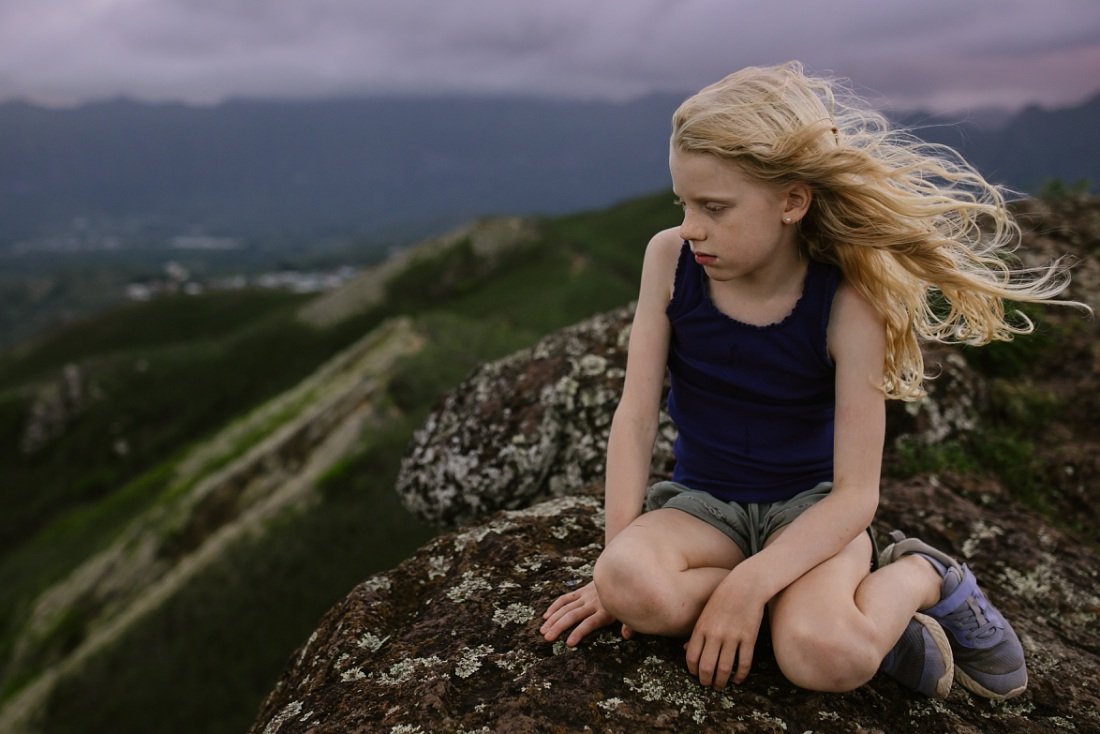 girl resting on a windy ridgeline lanikai pillbox hike