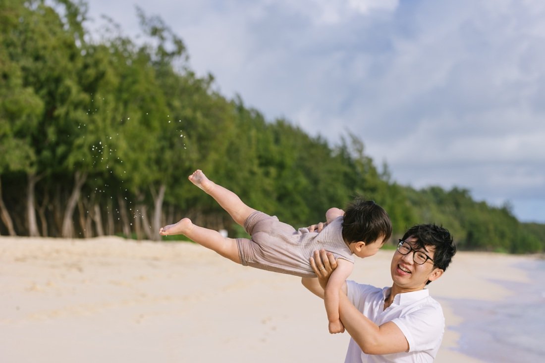 dad playing with son on the beach