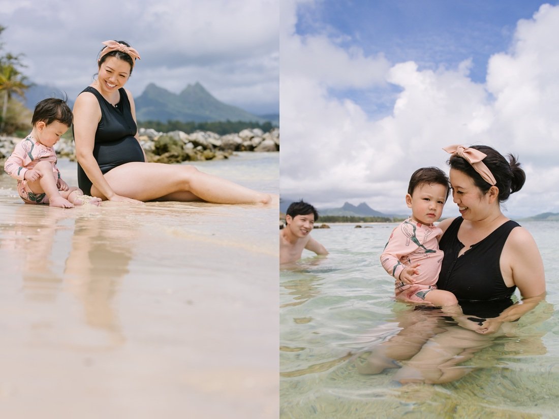 mom and baby play on a calm beach ini oahu