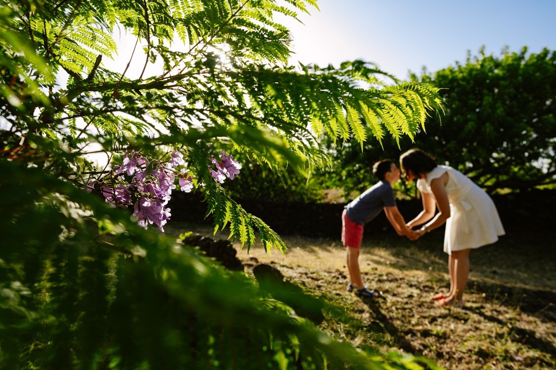 mom and son against flowering jacaranda trees in kula maui