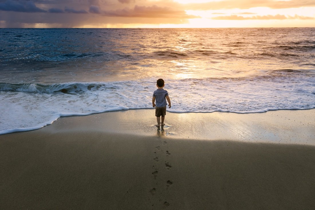 boy walking to the ocean at sunrise for laie beach family photos