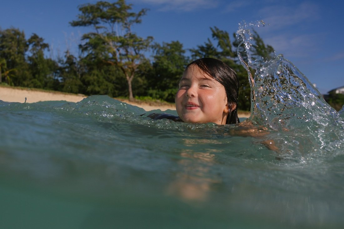 portrait of a girl splashing water during an underwater photoshoot in hawaii