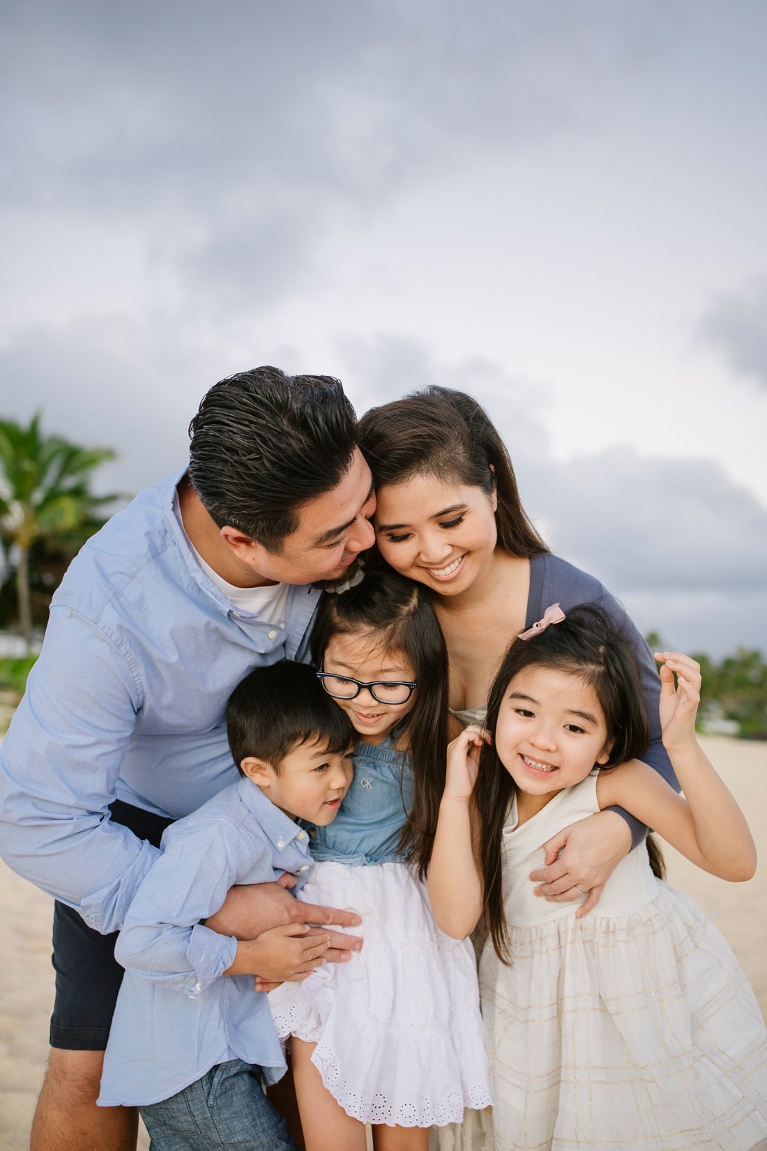 happy family hugging at lanikai beach by little bird photography