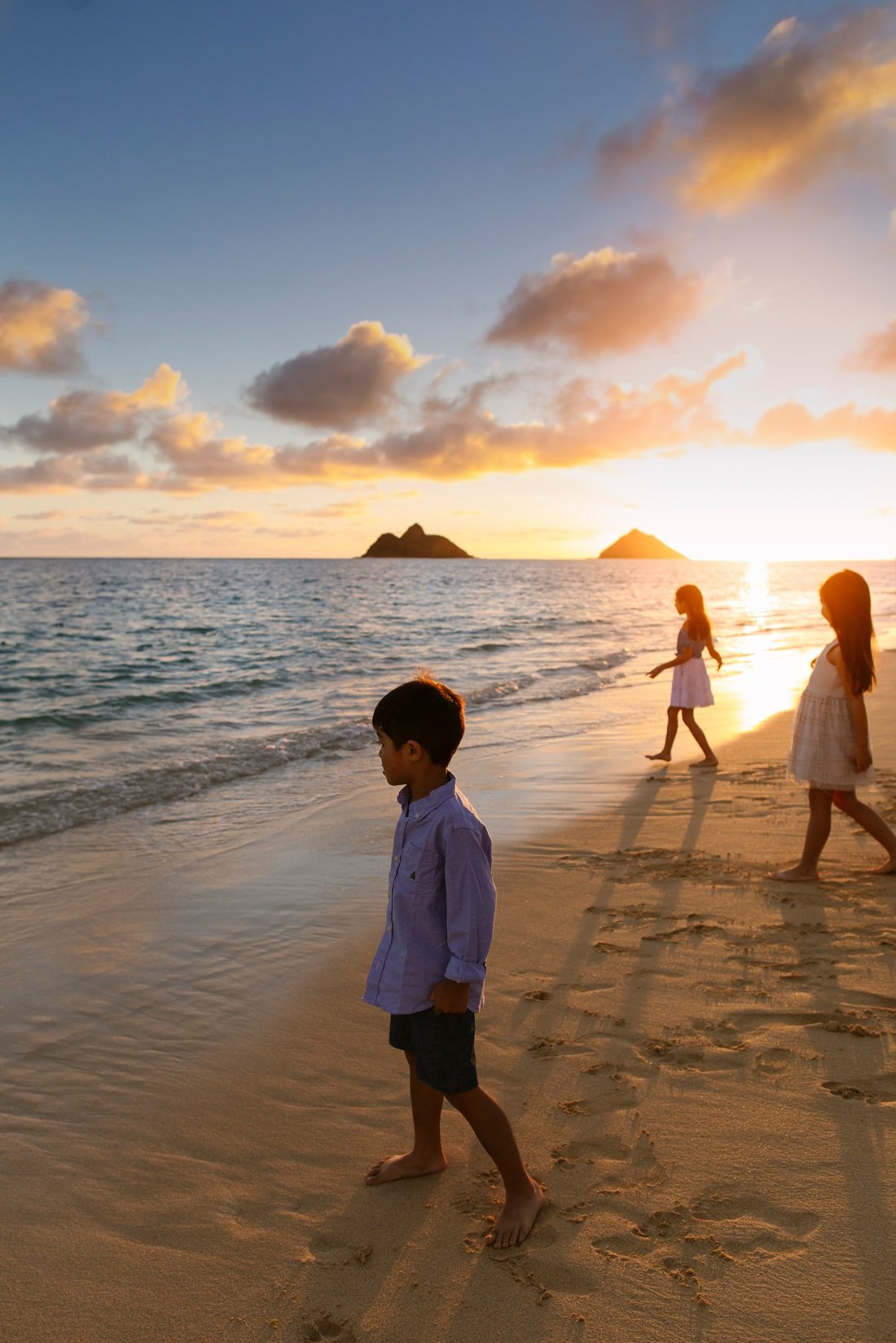 kids watching sunrise over the mokulua islets from lanikai beach oahu