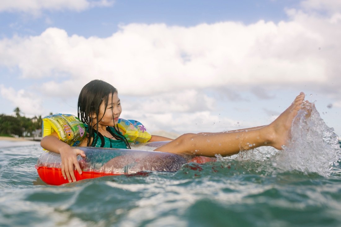 girl playing on a float during hawaii photo session