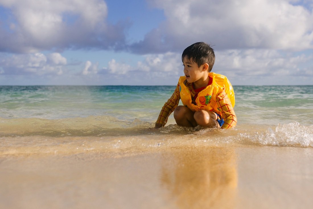 toddler boy plays in the surf at kailua beach