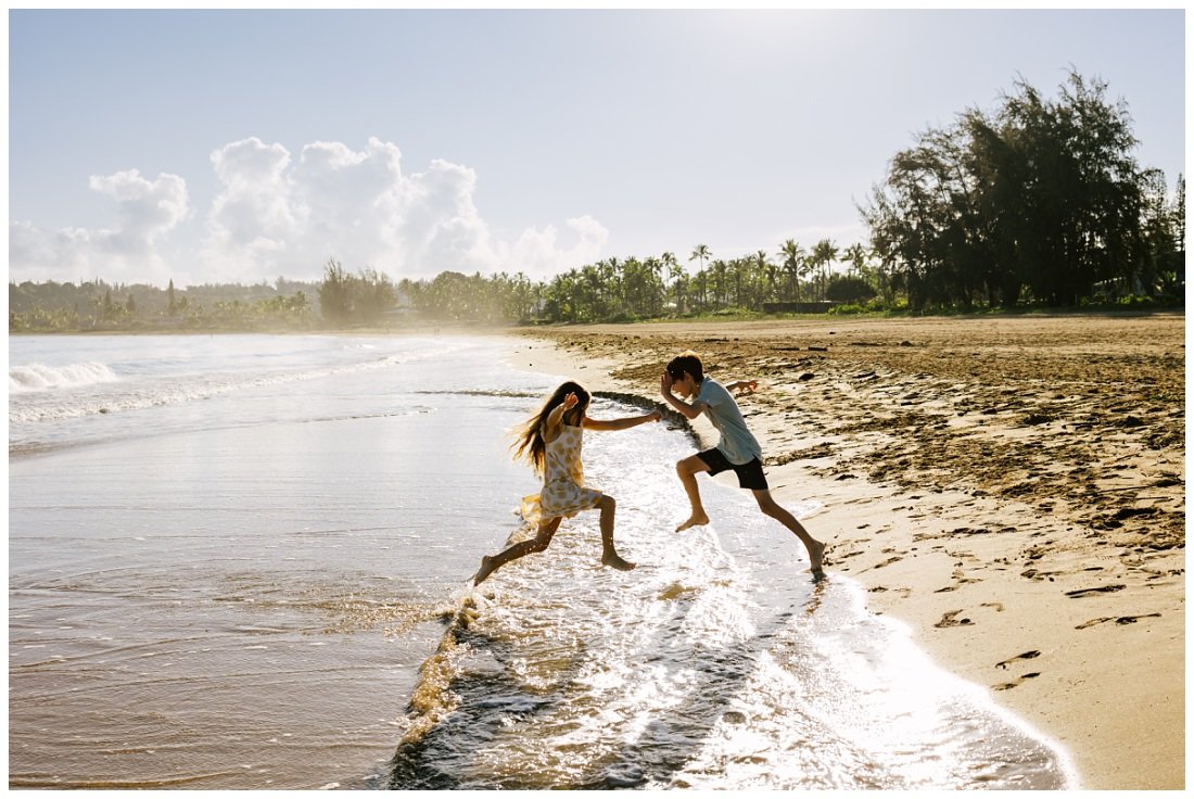 siblings jumping in synchrony north shore kauai vacation photos