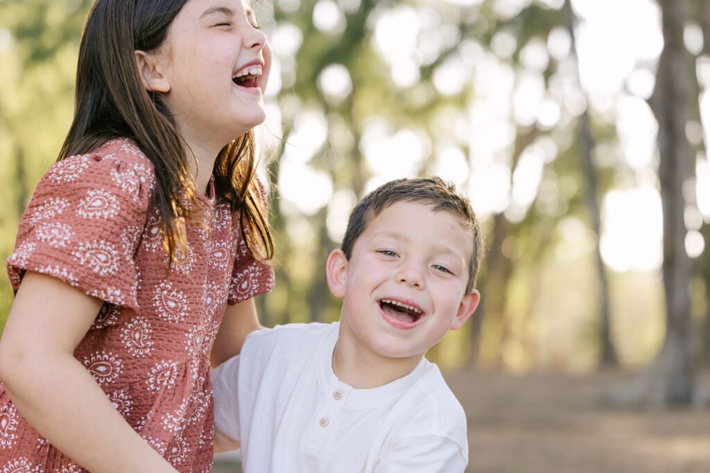 siblings laughing during photo session by little bird photography