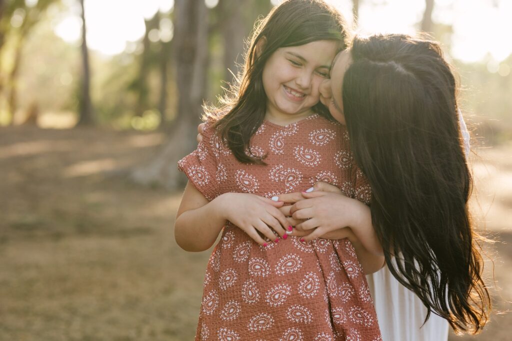 mom and daughter cuddle  during family photos in hawaii