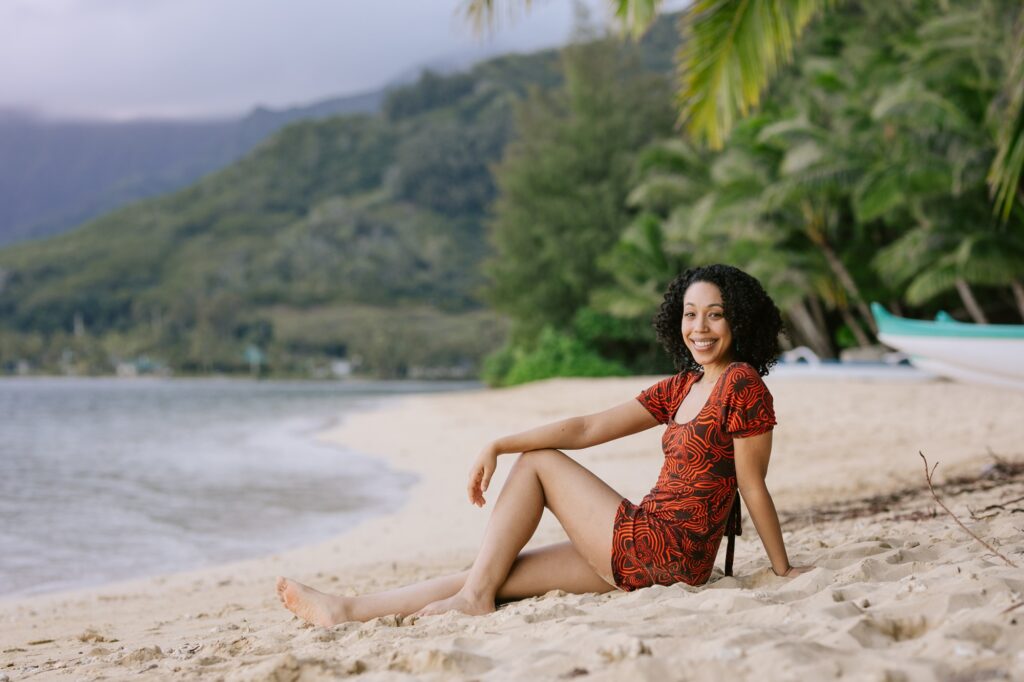 woman lounges on the beach at secret island in kualoa