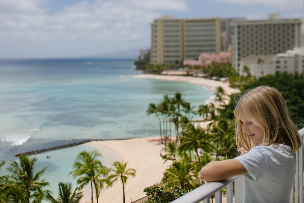 girl on a balcony of her hotel in waikiki with ocean views