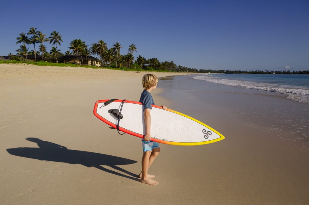 boy checking out the surf at kalama beach park in kailua