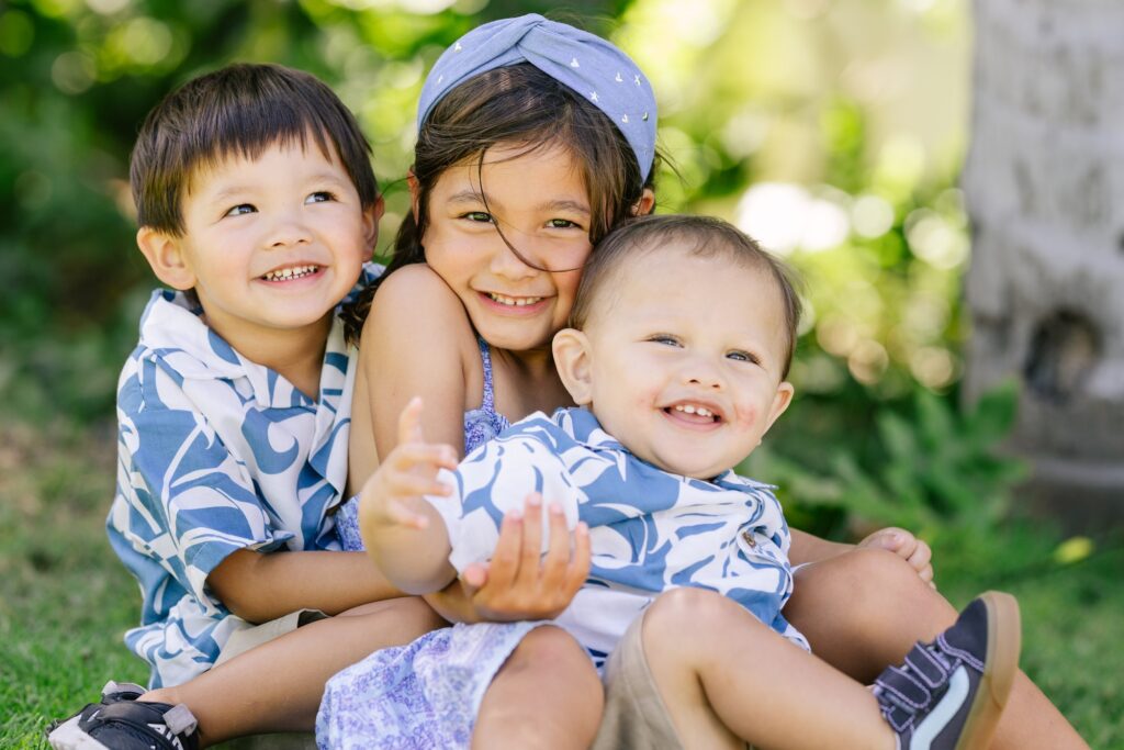 portrait of siblings hugging during a shared birthday celebration in oahu