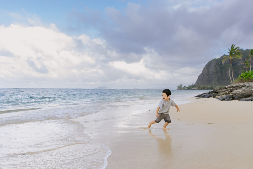 boy playing at kaaawa beach in oahu hawaii