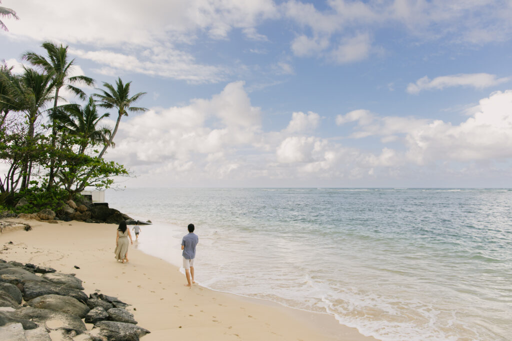 family walking along kaaawa beach in windward oahu for photos