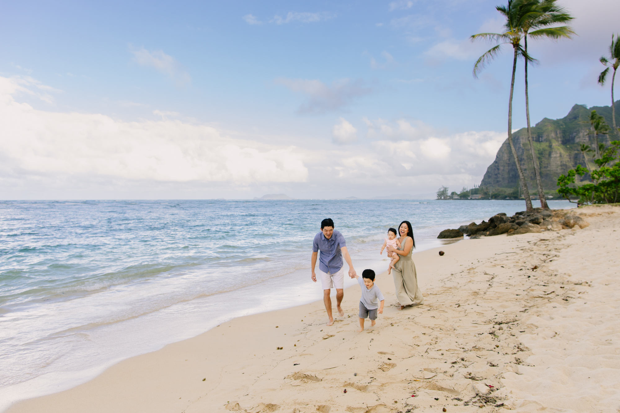 family of four walking on kaaawa beach in windward oahu