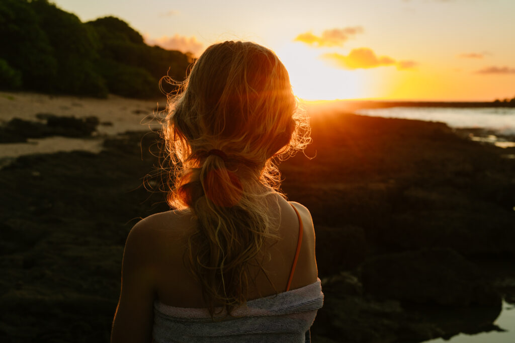 girl looking at sunset at turtle bay oahu