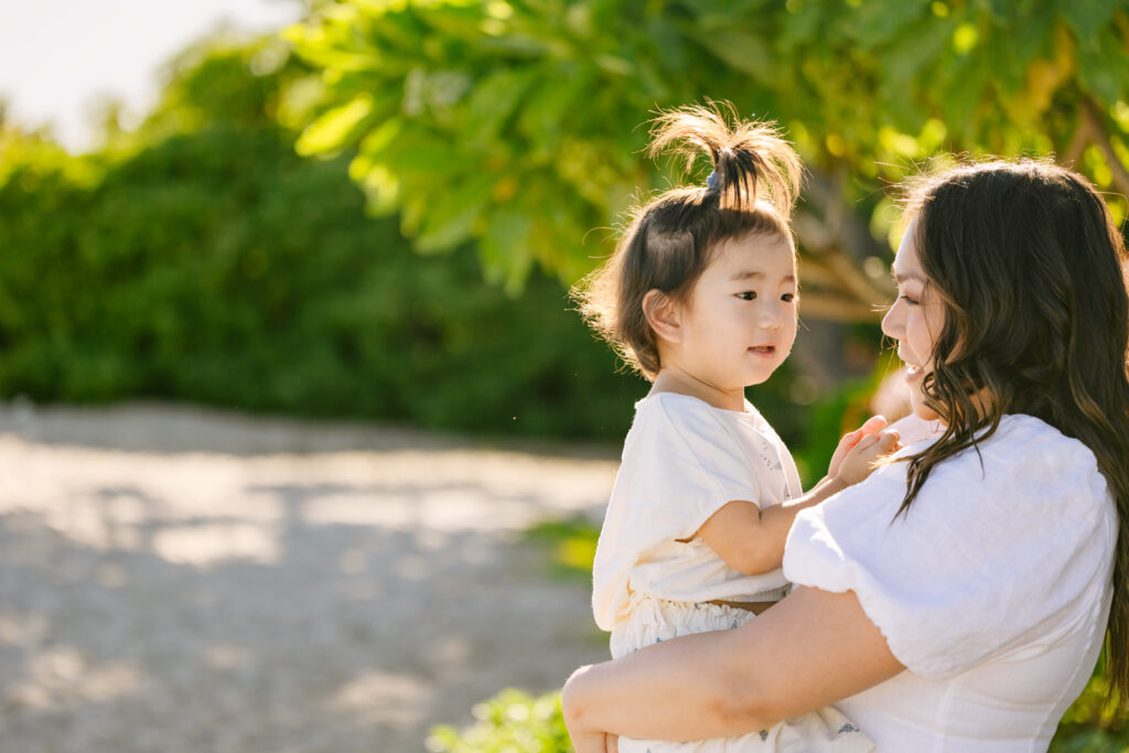 mom and baby snuggle during a family photo session in hawaii